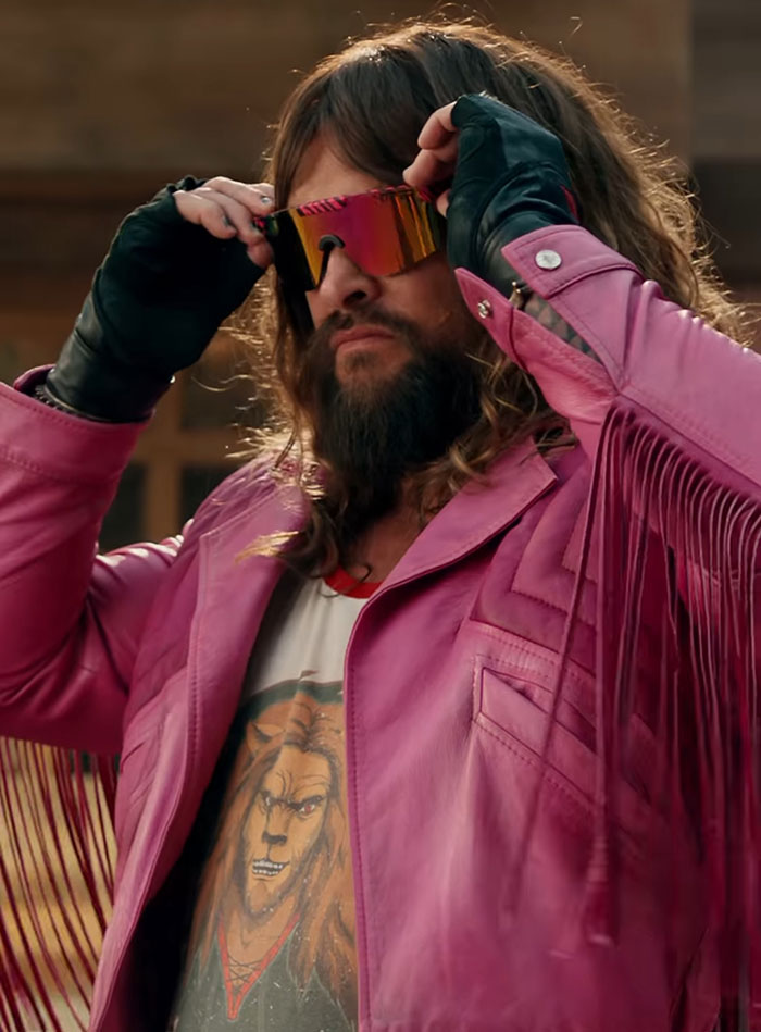 Man in pink jacket adjusting colorful sunglasses on set. Man in pink jacket adjusting colorful sunglasses on set.