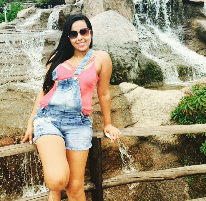 Woman in denim overalls and pink top by a waterfall, related to medical students and transplant mockery story. Woman in denim overalls and pink top by a waterfall, related to medical students and transplant mockery story.