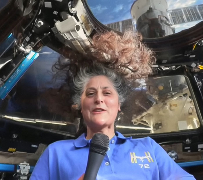 Person in a space capsule, hair floating, sparking Blue Origin conspiracy theories. Person in a space capsule, hair floating, sparking Blue Origin conspiracy theories.
