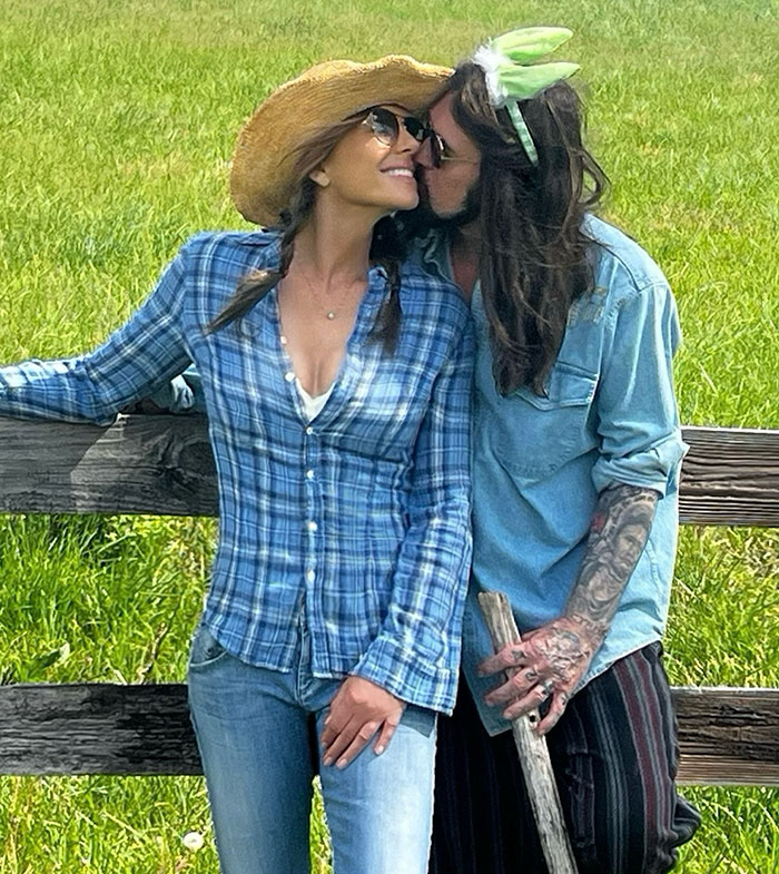 A couple in casual outfits sharing a moment by a fence on Easter, in a grassy field. A couple in casual outfits sharing a moment by a fence on Easter, in a grassy field.