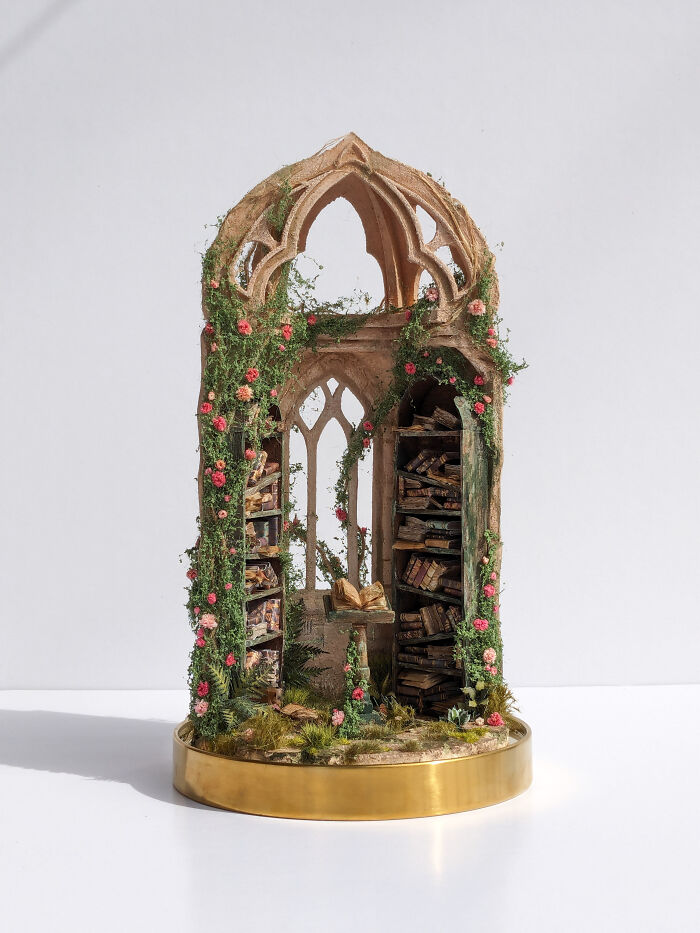 Miniature archway with shelves of books and vines, showcasing tiny worlds by Tamar Cohen.