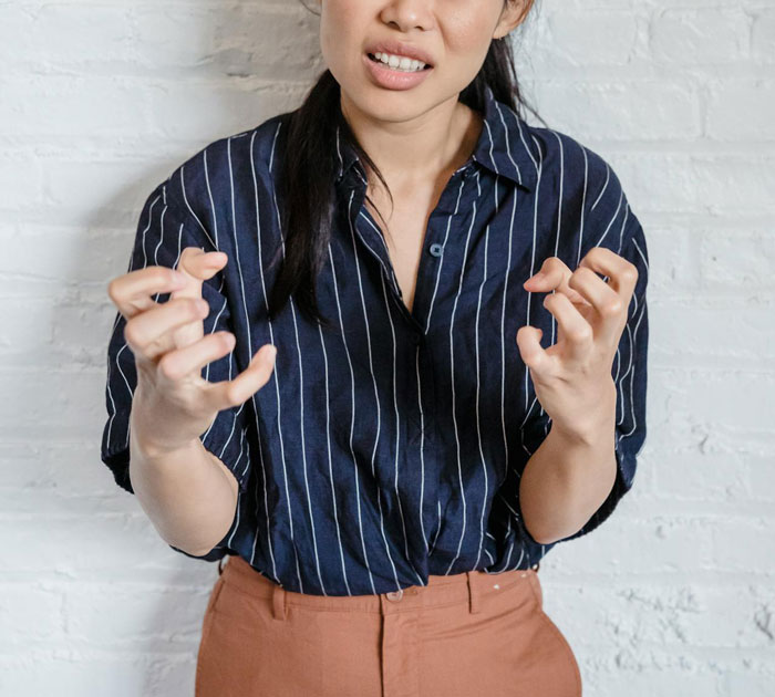 A woman in a striped shirt expressing frustration after a prank, embodying relationship tension. A woman in a striped shirt expressing frustration after a prank, embodying relationship tension.