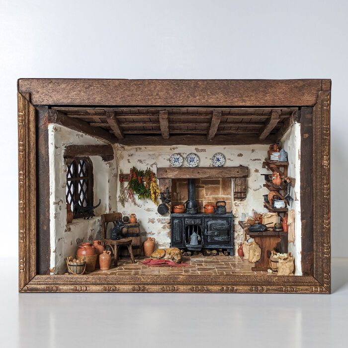 Miniature rustic kitchen scene by Tamar Cohen, featuring intricate details of pots, pans, and vintage decor.