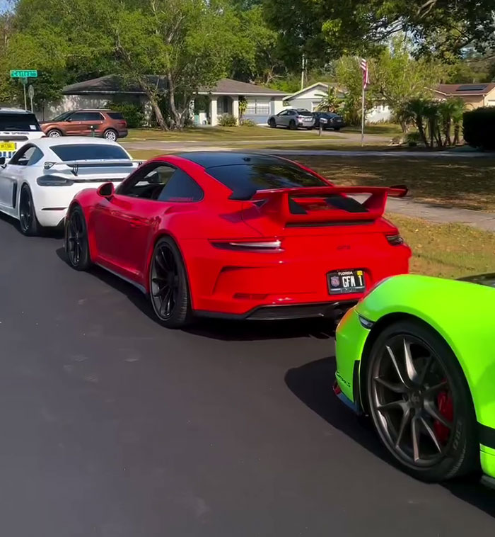 Sports cars lined up on a residential street, featuring a red car in the center. Sports cars lined up on a residential street, featuring a red car in the center.