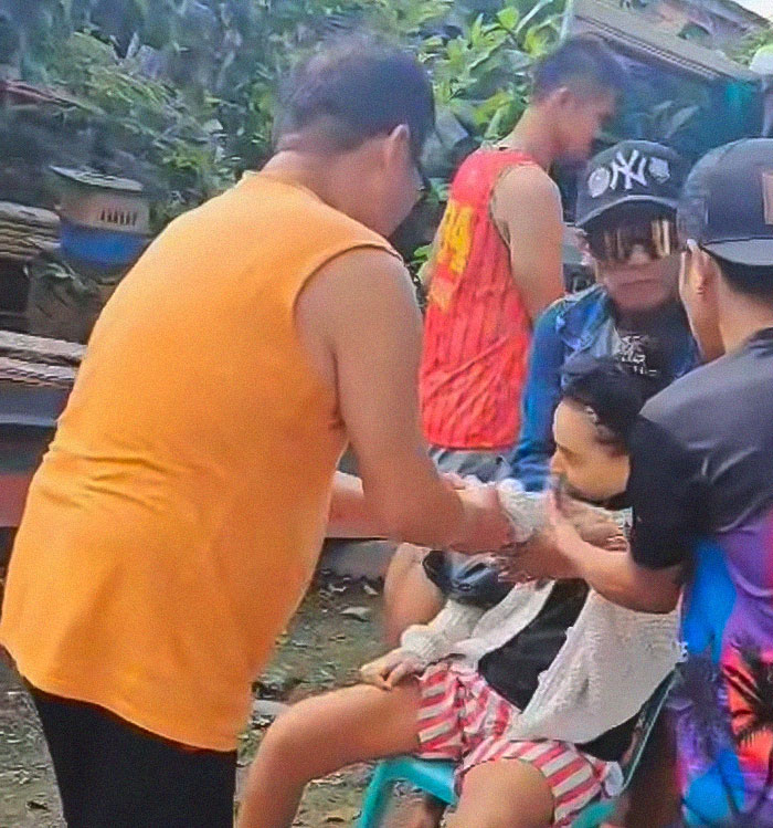 Group of people assisting a seated woman with a mysterious illness at an outdoor location. Group of people assisting a seated woman with a mysterious illness at an outdoor location.