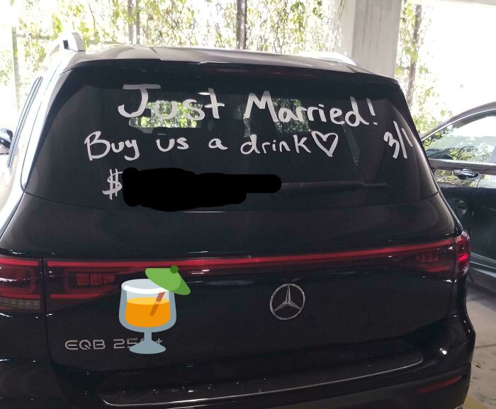 Mercedes SUV with "Just Married! Buy us a drink" written on the back window.