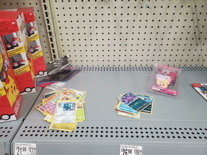 Pokemon card packs scattered on a store shelf, highlighting lack of self-awareness among shoppers in March.