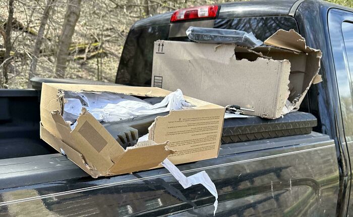 Damaged boxes on a truck, highlighting lack of self-awareness in packaging.