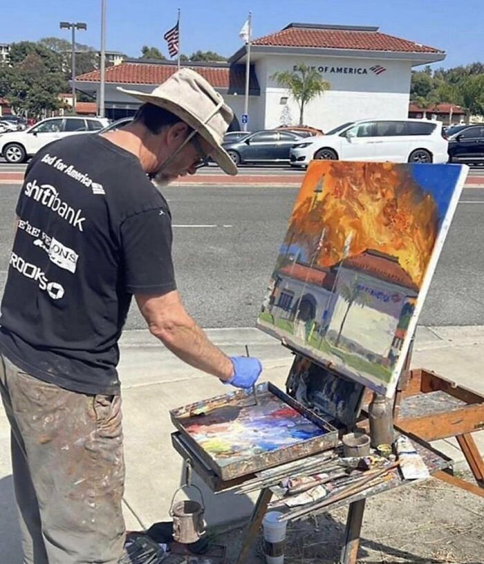 Painter creating artwork of a bank on fire, standing by an easel on a city sidewalk. Cursed images theme. Painter creating artwork of a bank on fire, standing by an easel on a city sidewalk. Cursed images theme.