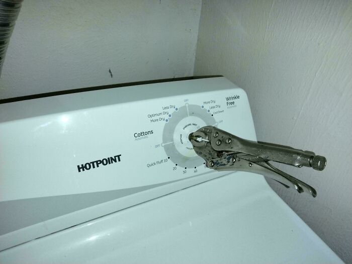 Washing machine dial repaired poorly with pliers, highlighting a failed repair attempt.