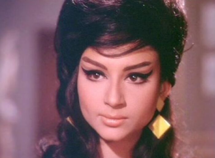 Vintage hairstyle with voluminous top and bold eyeliner, showcasing a classic yesteryear look.