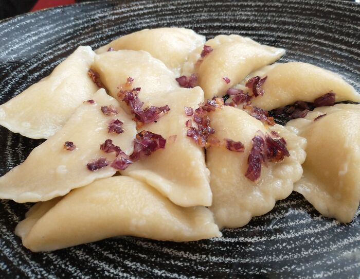 Top dish from different countries featuring dumplings topped with fried onions.