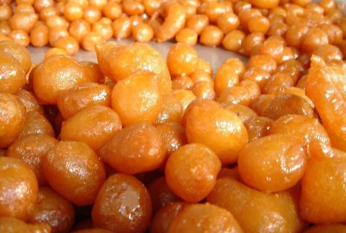 Golden fried sweets from different countries' top dish showcase, glistening with syrup.