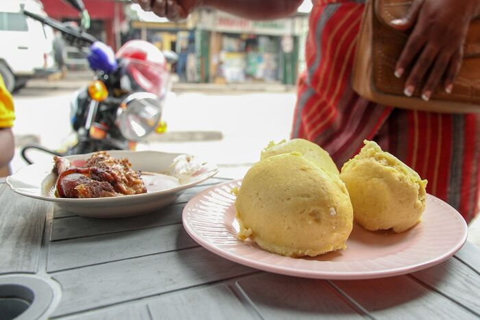 Person serving top dish from different countries on an outdoor table.