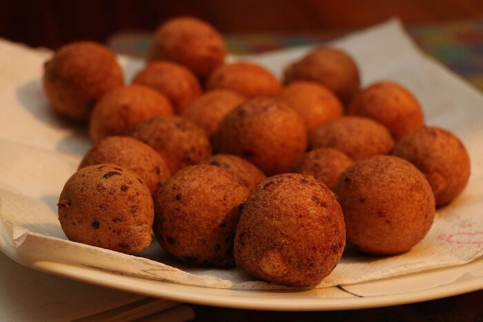 Plate of savory fried balls, a top dish from different countries, served on a white napkin.