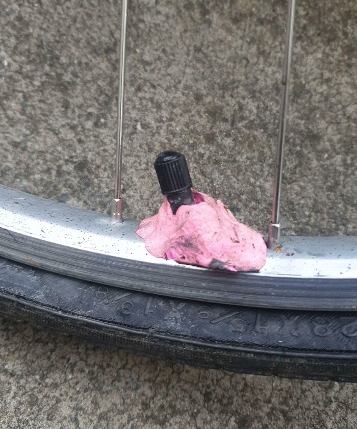 Bicycle tire valve patch repair attempt using pink gum, highlighting a repair fail.