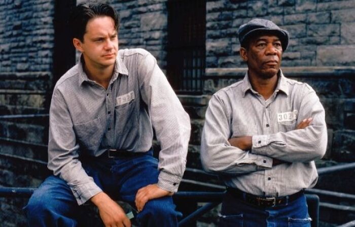 Two men in prison uniforms stand outside, a scene from an emotional, tear-inducing movie.