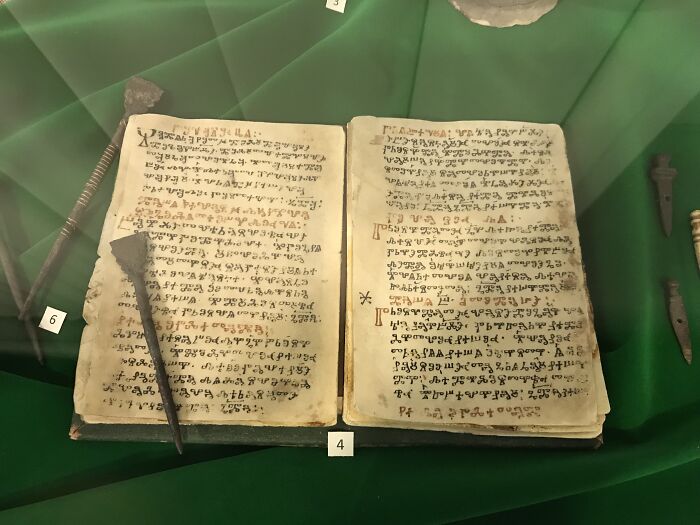 Ancient written text displayed on an open book with historic tools, showcasing one of the oldest writings in the world.