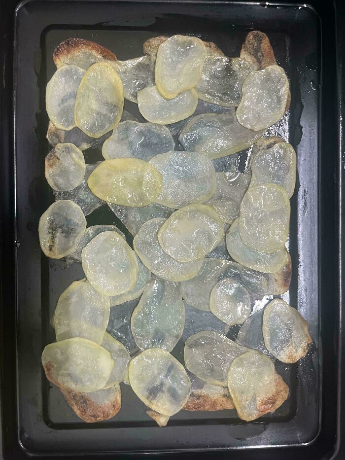 Clear potato slices on a baking sheet, illustrating a cooking mishap.