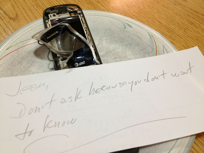Damaged phone with a note saying, "Don't ask because you don't want to know." A worse day scenario.