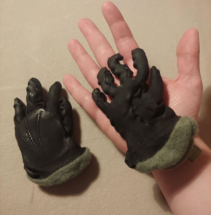 Tiny black gloves humorously compared to a regular hand, illustrating a worse day moment.