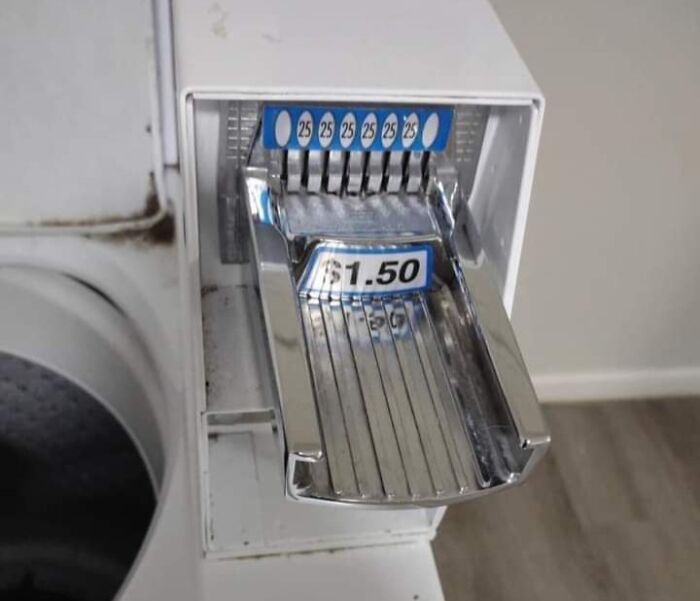 Coin slot on a malfunctioning laundry machine with a $1.50 label, illustrating a frustrating day.