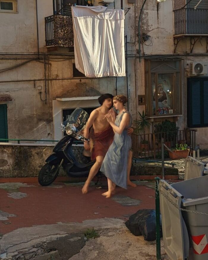 Classical figures in a modern urban setting with a scooter and laundry.