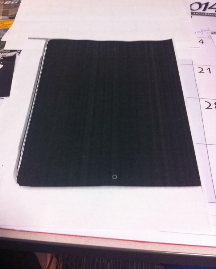 Close-up of a sheet of paper resembling a closed iPad lying on a desk calendar, capturing a moment of confusion.