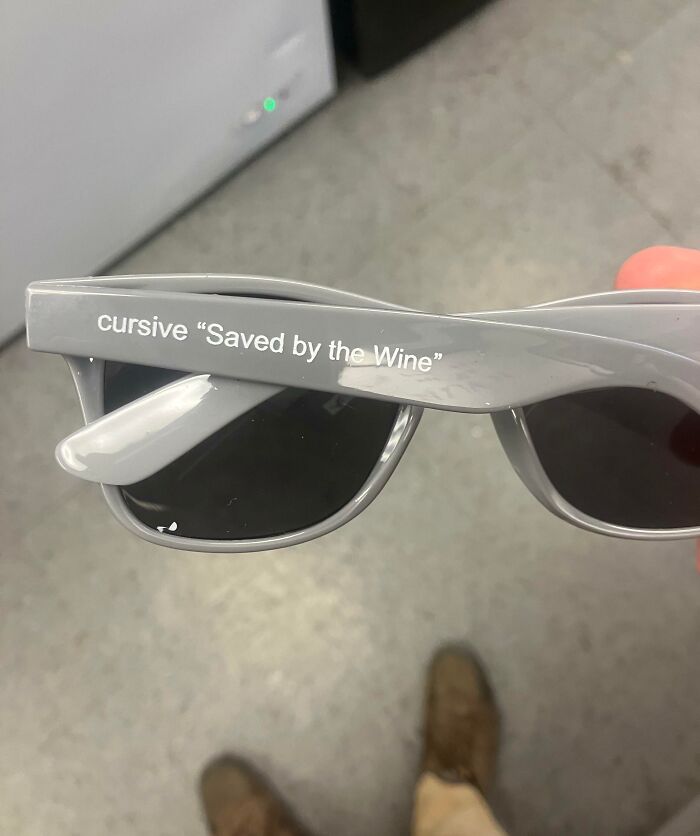 Gray sunglasses with humor text "Saved by the Wine," possibly from a bad day experience.