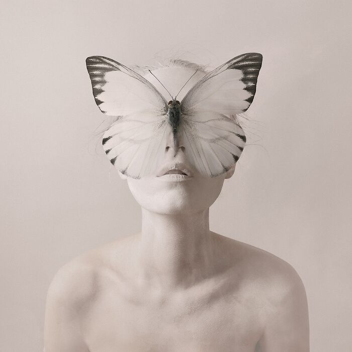 Artist's surreal self-portrait with butterfly covering her eyes in a dreamy Photoshop creation.