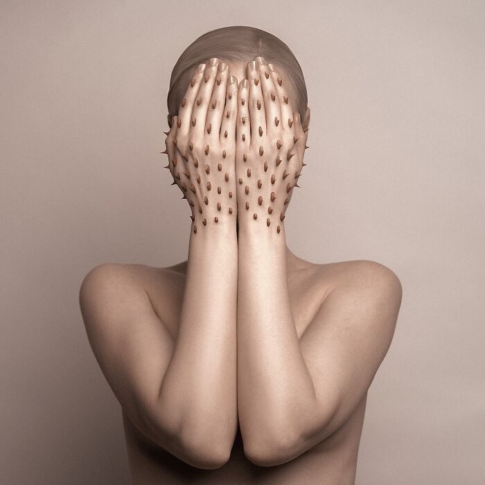 Surreal self-portrait of artist with eyes covered by spiked hands, blending dreamlike elements in Photoshop.