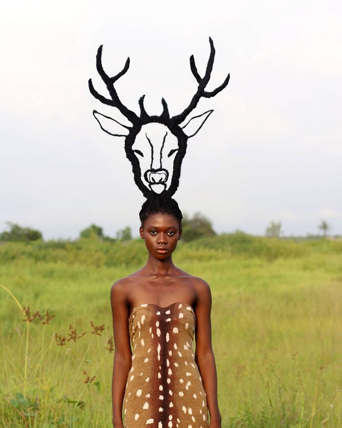 Woman with hair sculpted into a deer design, standing in a field, showcasing creative hair sculpture artistry.