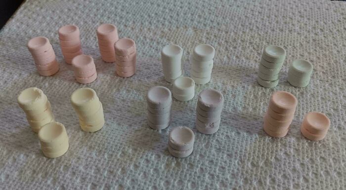 Stacks of various colored pills arranged on a textured paper towel in a completely unremarkable photo.