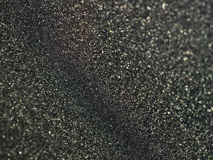 Close-up of a textured surface covered in tiny sparkling particles in an entertaining unremarkable photo.