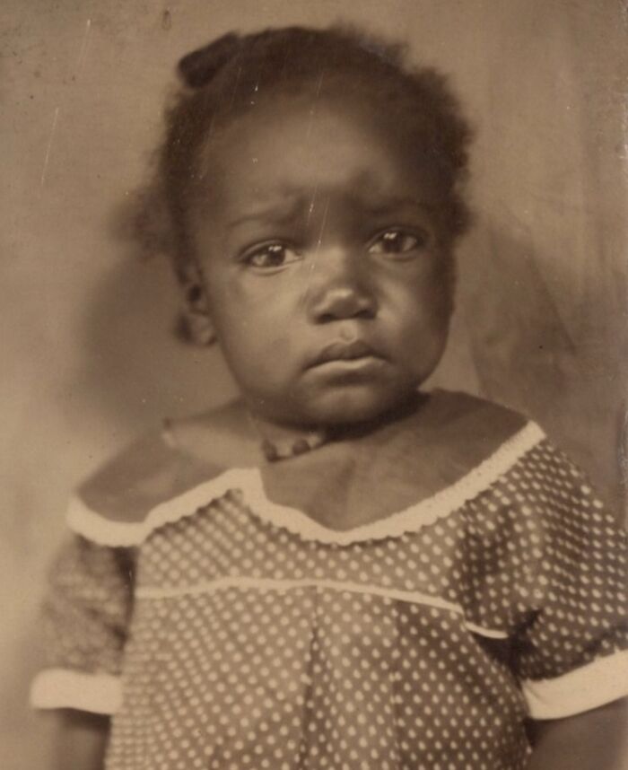 Young African American child in a vintage portrait reflecting the strength and history of African Americans over a century ago.