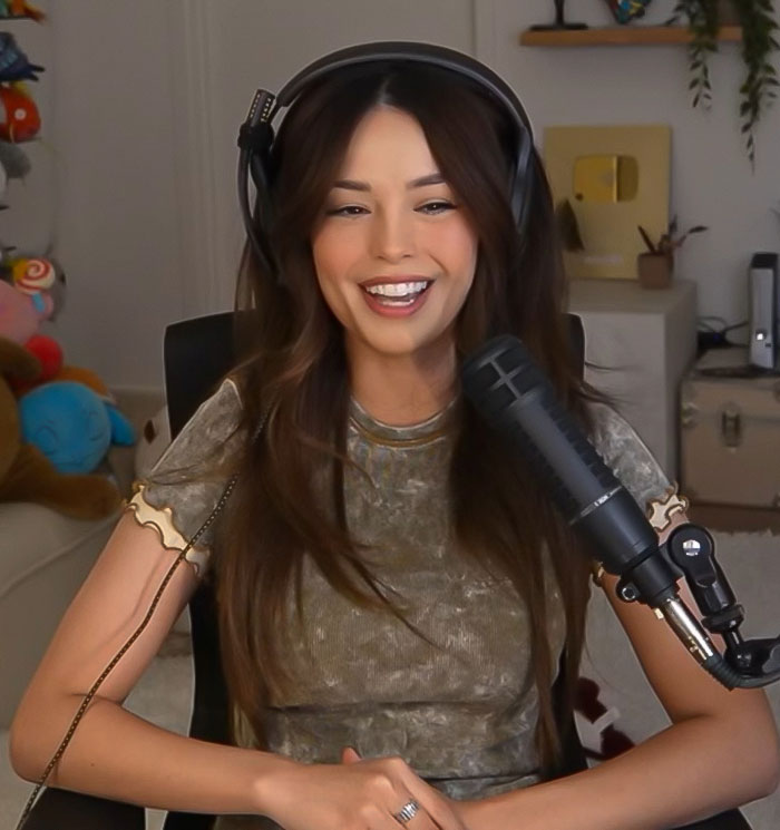 Streamer discussing 'Minecraft' scene and Jason Momoa's set behavior in her home studio setup, wearing headphones. Streamer discussing 'Minecraft' scene and Jason Momoa's set behavior in her home studio setup, wearing headphones.