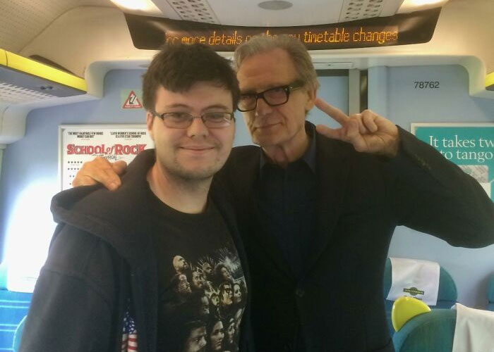 Two people posing together inside a train, with one making a peace sign, highlighting a celebrity encounter.
