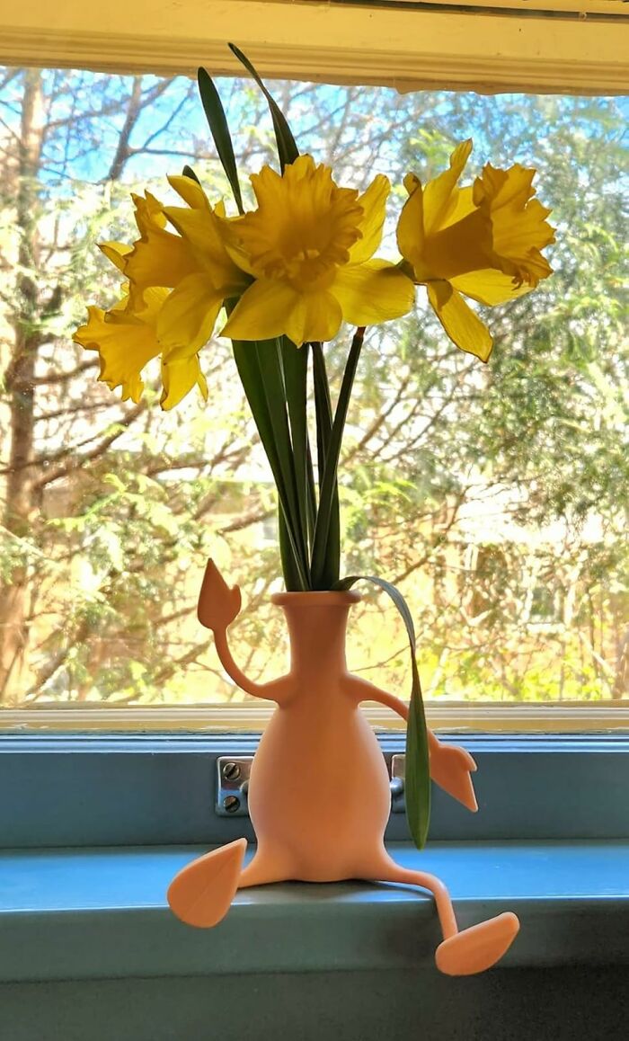 Yellow daffodils arranged in a playful flower vase sitting on a windowsill, perfect funny Mother's Day gifts idea.