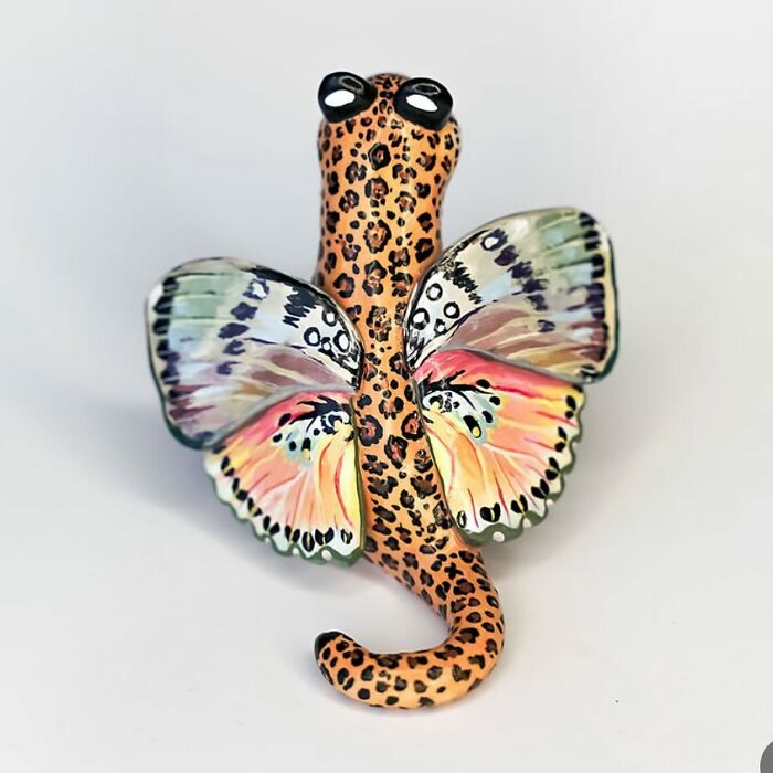 Leopard-patterned pocket-sized animal figurine with colorful butterfly wings.