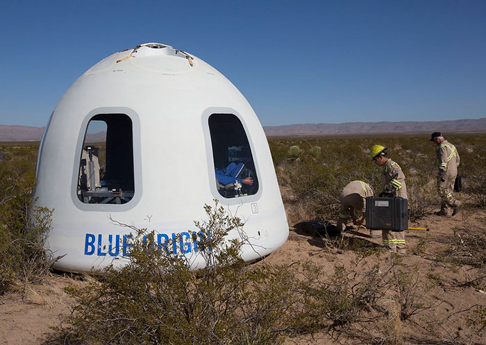 Blue Origin capsule landed in desert with personnel working nearby amidst conspiracy discussions. Blue Origin capsule landed in desert with personnel working nearby amidst conspiracy discussions.