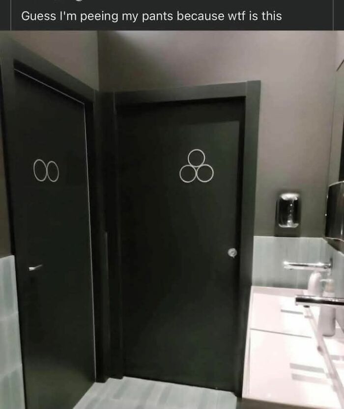 Restroom doors with unusual overlapping circle symbols seen in a funny dad joke post from a Facebook group.