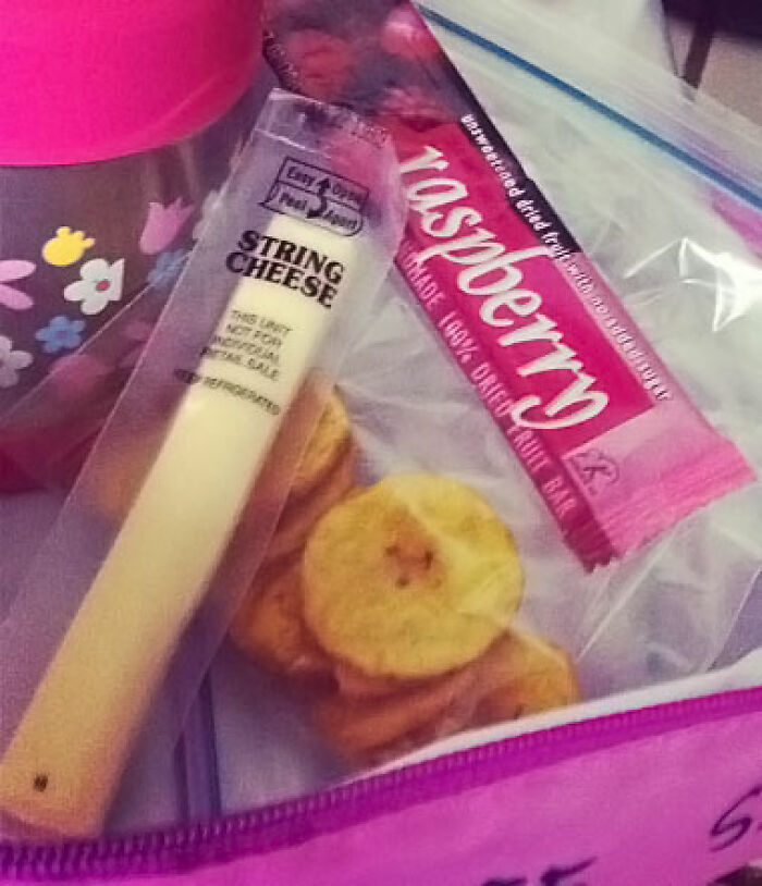 Snack pack with string cheese, dried raspberry bar, and banana chips in a floral lunch tote.