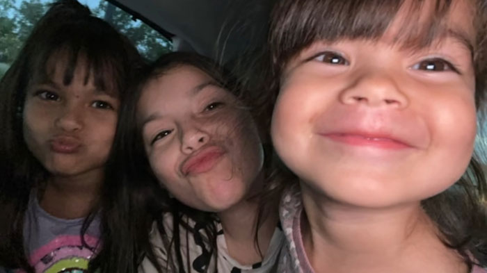 Three smiling children pose closely together in a joyful moment indoors. Three smiling children pose closely together in a joyful moment indoors.