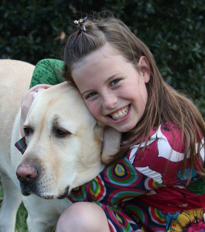 Young girl smiling and hugging Breuer, the Labrador winning Instagram with his late brother’s spirit alive outdoors. Young girl smiling and hugging Breuer, the Labrador winning Instagram with his late brother’s spirit alive outdoors.