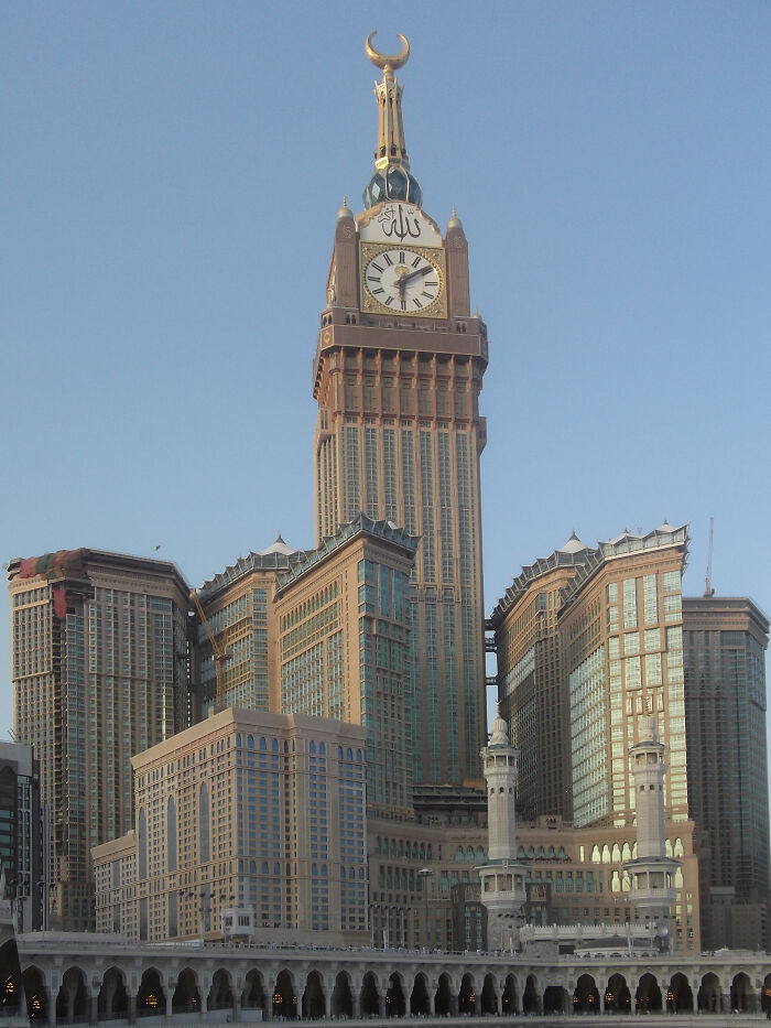 World's tallest buildings, Abraj Al Bait Towers in Mecca with clock tower and crescent in clear sky.