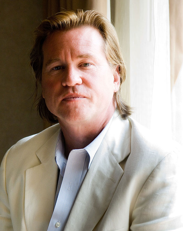 Legendary Hollywood actor in a light suit, sitting by a window, with a thoughtful expression. Legendary Hollywood actor in a light suit, sitting by a window, with a thoughtful expression.