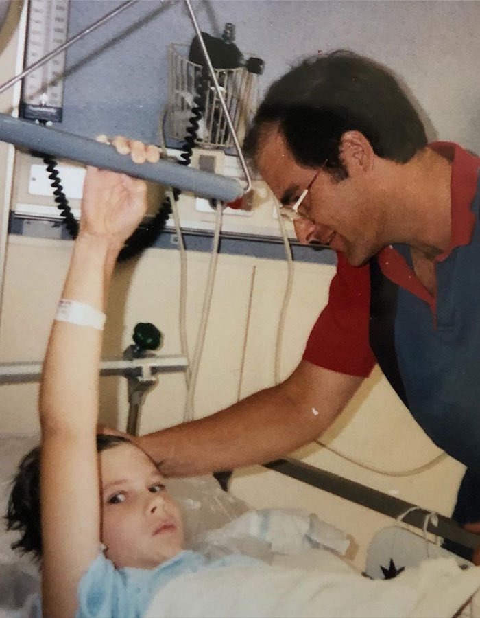 A person in a hospital bed with a man by their side after a cement truck crash. A person in a hospital bed with a man by their side after a cement truck crash.
