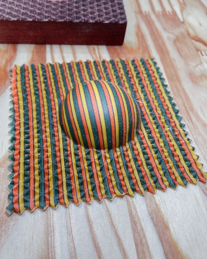 Colorful handcrafted pasta with striped patterns on a wooden surface.