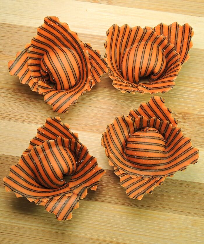 Handcrafted pasta featuring vibrant colors and intricate patterns on a wooden board.