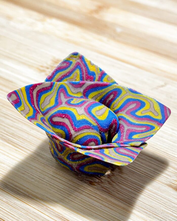 Colorful handcrafted pasta with vibrant patterns on a wooden surface.